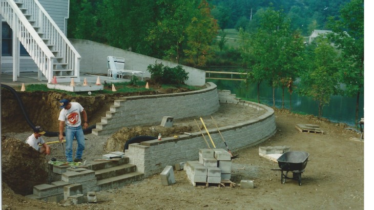 Brick Paver Construction worksers building retaining walls with Shovels and Wheel barrels