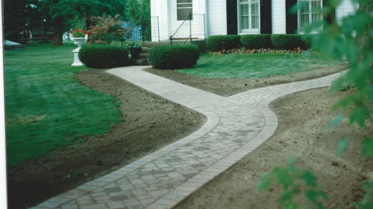 A brick pathway leading up to the front and back of a house
