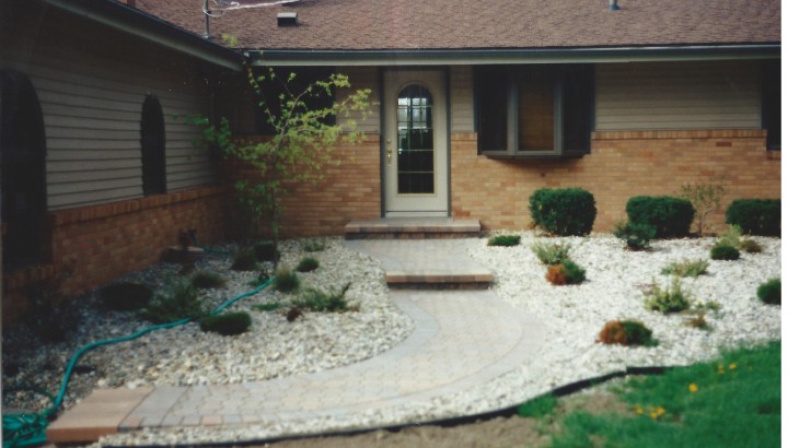 A brick walkway leading up to the front door of a home