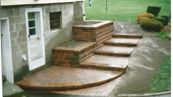 Brick walkway leading into the side of a house