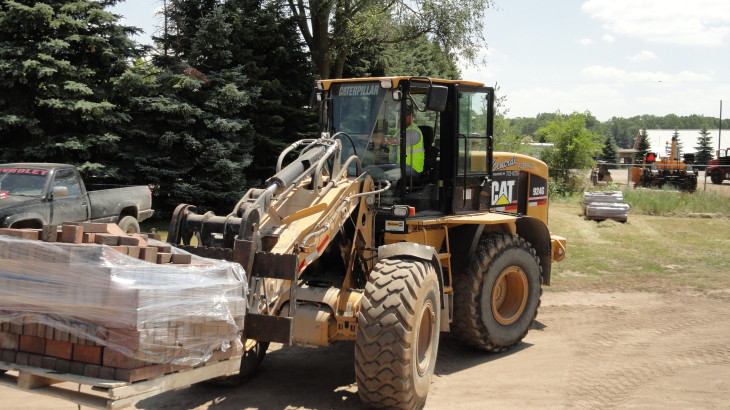 A Cat forklift moving a of pallet of bricks