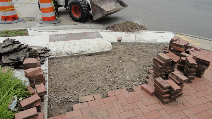 A stack of bricks ready to placed onto the ground to create a brick pathway