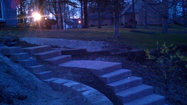 A night image of brick steps that lead up to the back entrance of a home