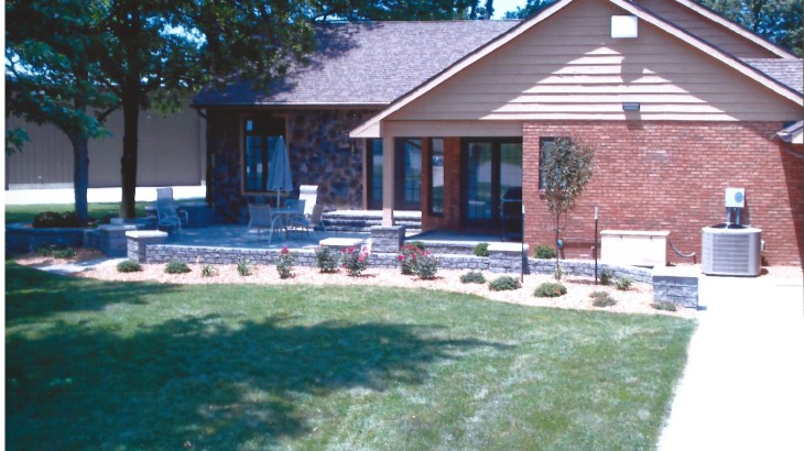 An outdoor brick patio with a brick fence surrounding