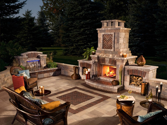 A beautiful fashioned brick fireplace and brick ground with chairs ready for people to enjoy the night